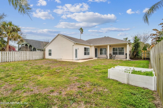 back of house with stucco siding, a lawn, a patio area, ceiling fan, and a fenced backyard