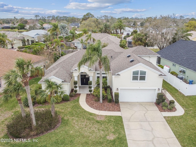 view of front of house with a shingled roof, a residential view, fence, and a front yard