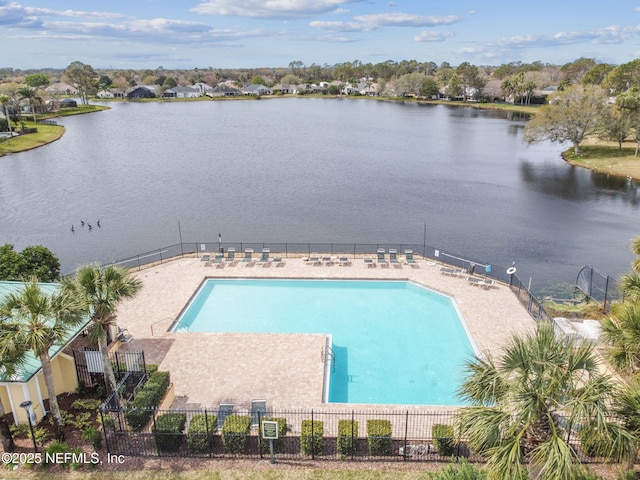 pool featuring a water view, a patio area, and fence