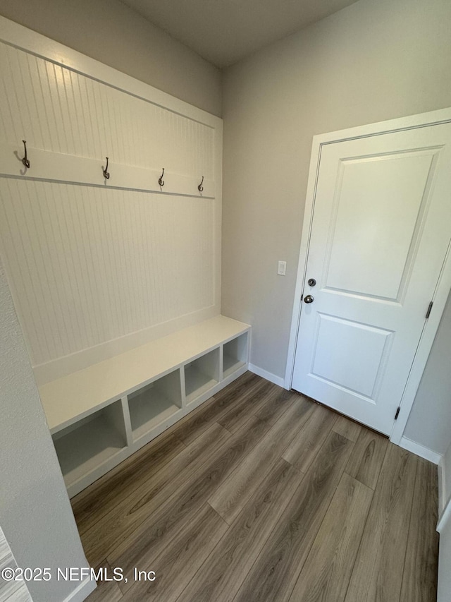 mudroom featuring dark wood-type flooring and baseboards