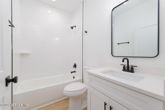 bathroom featuring toilet, bathtub / shower combination, wood finished floors, and vanity