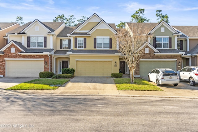 view of property with an attached garage, concrete driveway, and stucco siding