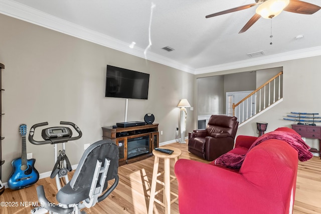 living room featuring visible vents, wood finished floors, and ornamental molding