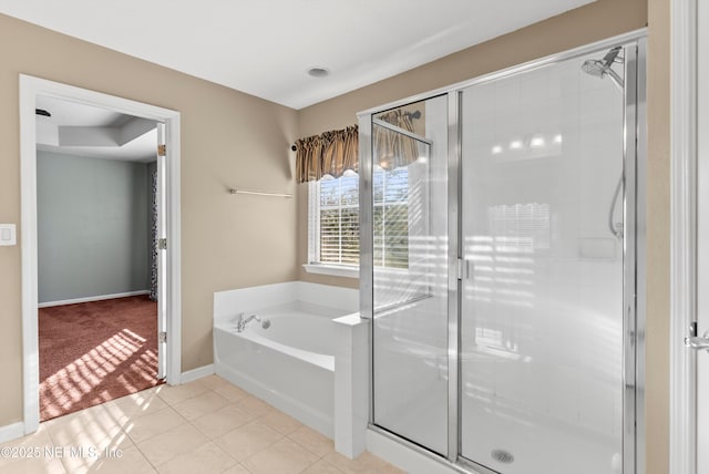 bathroom with tile patterned floors, a shower stall, baseboards, and a bath