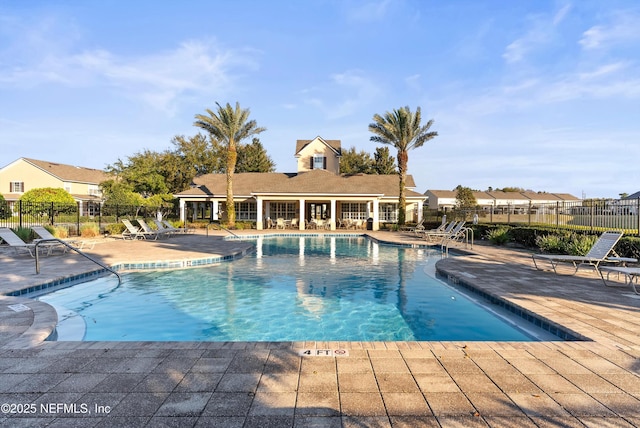 community pool featuring fence and a patio