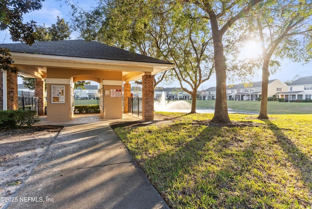 view of property's community featuring a residential view, fence, and a yard