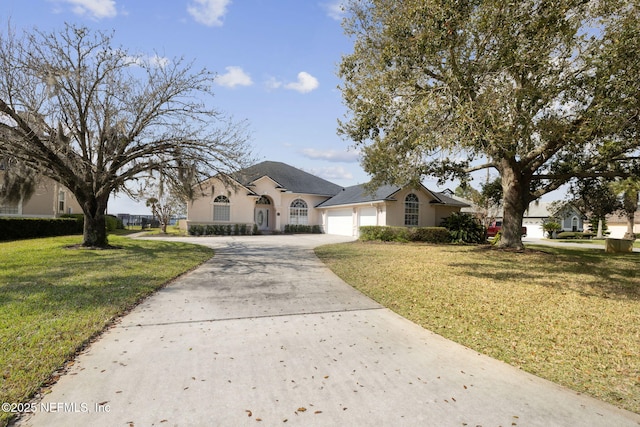 view of front of house featuring an attached garage, concrete driveway, a front yard, and stucco siding