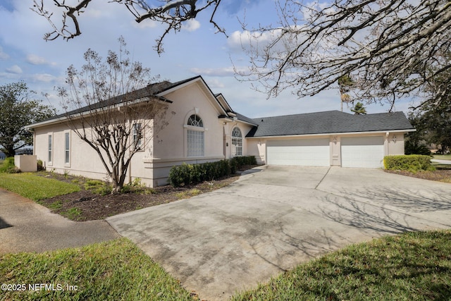 view of side of home featuring an attached garage, concrete driveway, and stucco siding