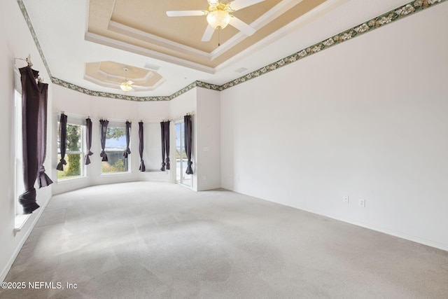 spare room with ceiling fan, carpet floors, visible vents, a raised ceiling, and crown molding