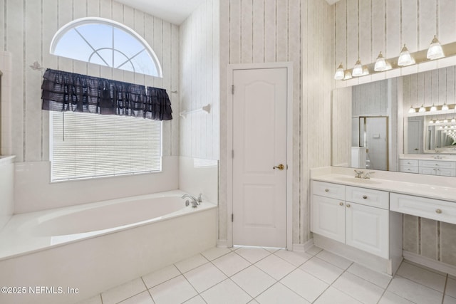 full bathroom featuring a garden tub, vanity, and tile patterned floors