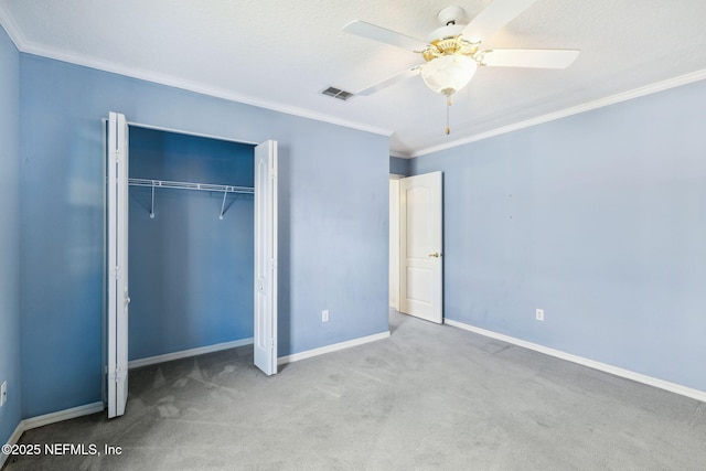 unfurnished bedroom featuring carpet, visible vents, ornamental molding, a ceiling fan, and baseboards