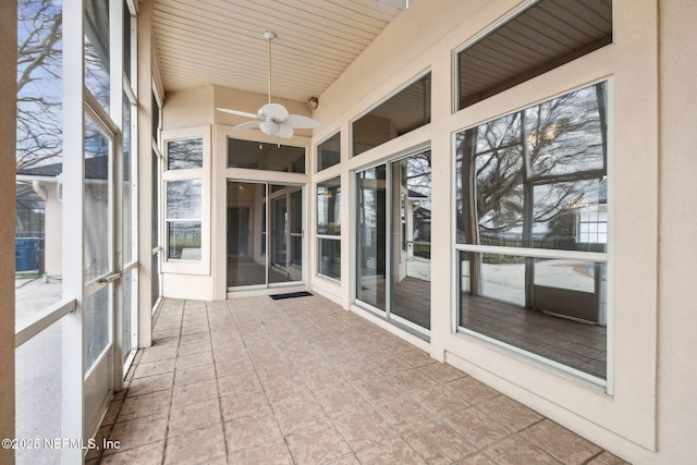 unfurnished sunroom featuring a ceiling fan