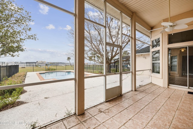 unfurnished sunroom with a ceiling fan