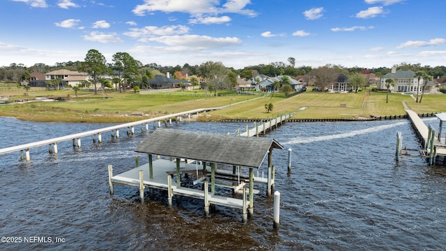 dock area with a water view, a yard, and boat lift