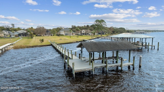 view of dock with a yard, a water view, and boat lift