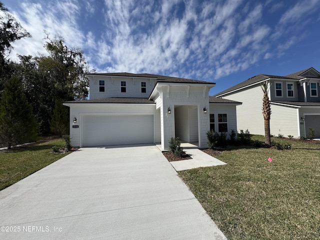 view of front facade with concrete driveway and a front lawn