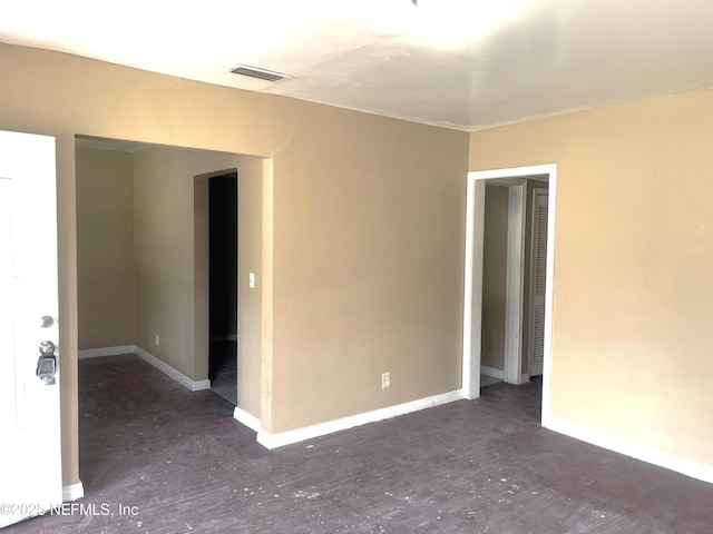 unfurnished room featuring baseboards and visible vents