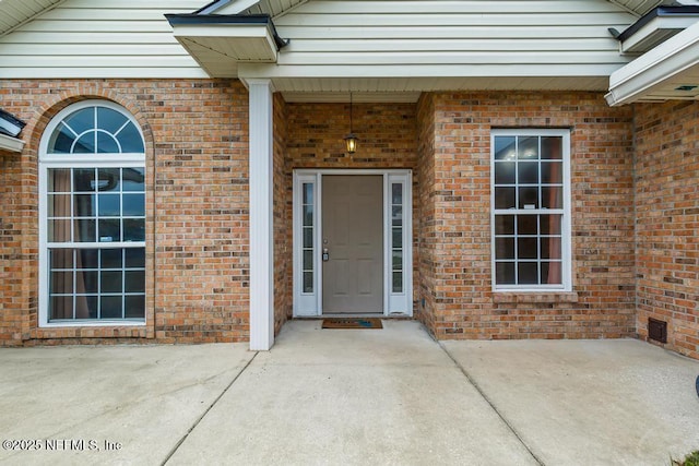 doorway to property featuring brick siding