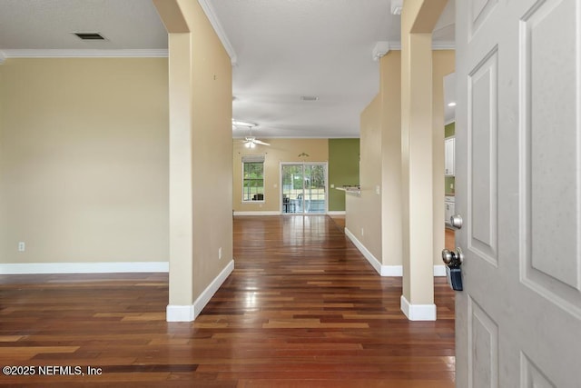 foyer entrance with hardwood / wood-style flooring, visible vents, ornamental molding, and baseboards