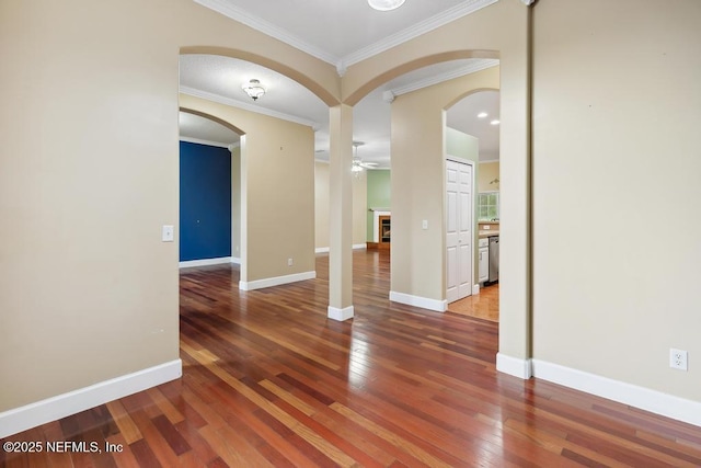 unfurnished room with hardwood / wood-style flooring, a fireplace, baseboards, and ornamental molding