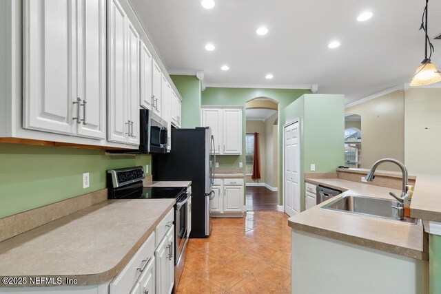 kitchen featuring arched walkways, light tile patterned floors, stainless steel appliances, white cabinets, and a sink