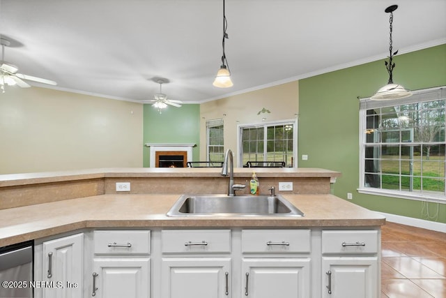 kitchen featuring hanging light fixtures, ceiling fan, crown molding, and a sink