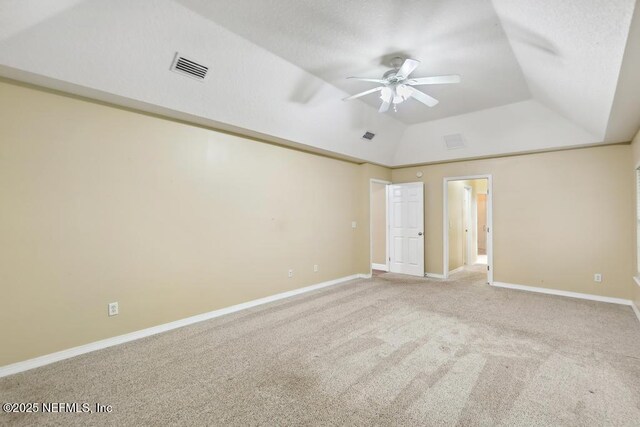 unfurnished room with carpet floors, lofted ceiling, visible vents, ceiling fan, and baseboards