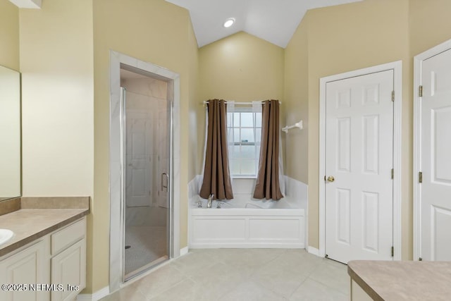 full bath with vanity, vaulted ceiling, a bath, tile patterned floors, and a stall shower