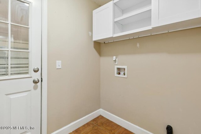 washroom featuring cabinet space, baseboards, washer hookup, and tile patterned flooring