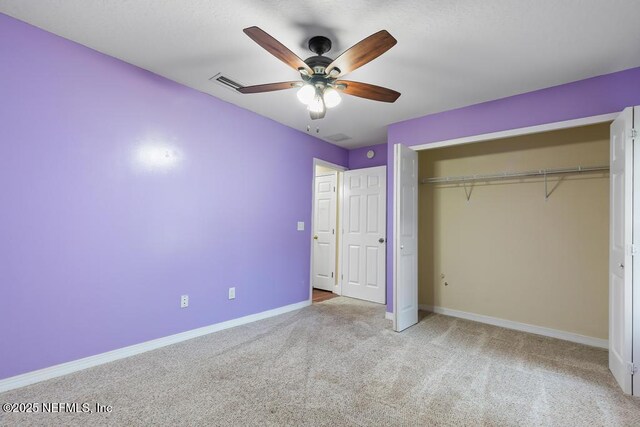 unfurnished bedroom with ceiling fan, carpet flooring, visible vents, baseboards, and a closet