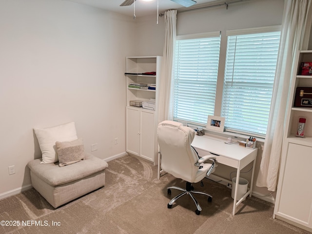 home office featuring light carpet, a ceiling fan, and baseboards