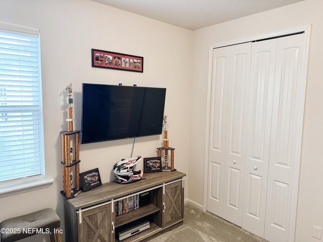 bedroom featuring light carpet and a closet