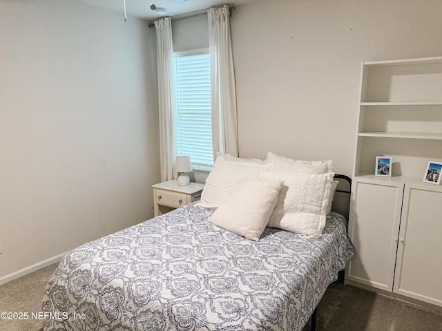 bedroom with dark colored carpet and baseboards