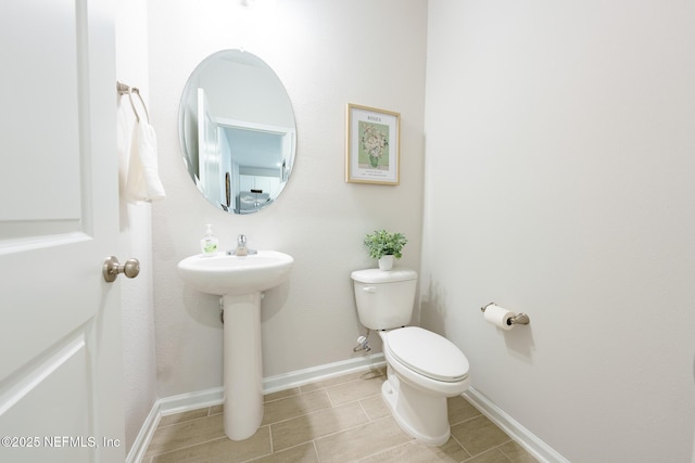 half bathroom with toilet and baseboards