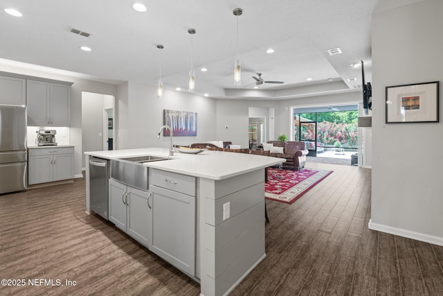 352 Bronson Pkwy, Saint Augustine, FL 32095 - kitchen with appliances with stainless steel finishes, dark wood-type flooring, a center island with sink, a raised ceiling, and recessed lighting