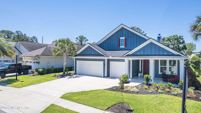 352 Bronson Pkwy, Saint Augustine, FL 32095 - view of front of house with board and batten siding, covered porch, concrete driveway, and a front lawn