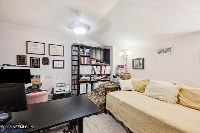 bedroom with a textured ceiling, a textured wall, vaulted ceiling, and visible vents