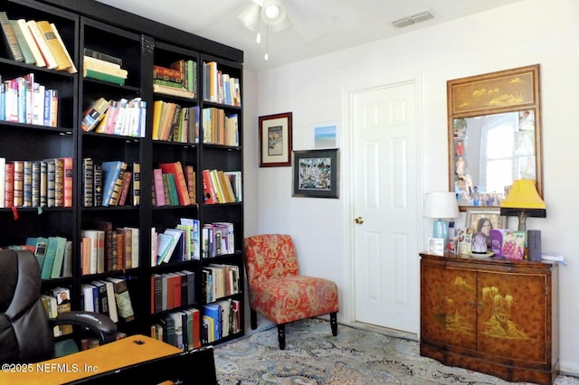 living area with visible vents and ceiling fan