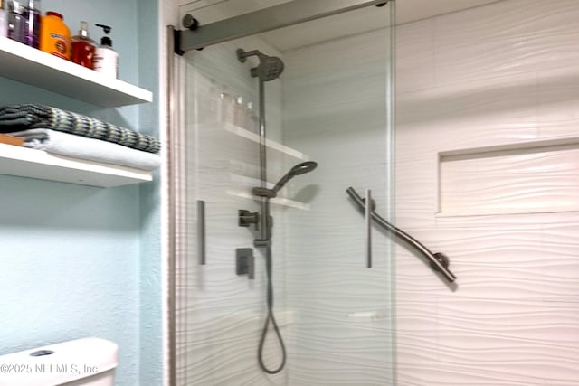 full bathroom featuring toilet and a stall shower
