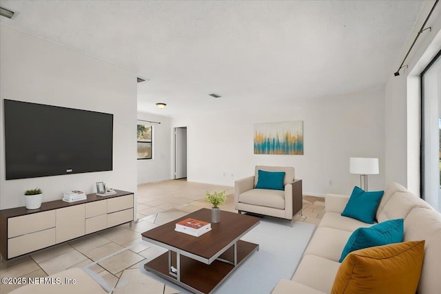 living area with light tile patterned floors and visible vents