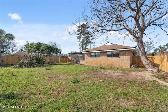 view of yard featuring a sunroom and a fenced backyard