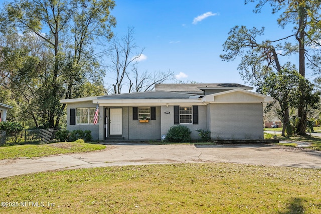 ranch-style house featuring a front yard, brick siding, and fence