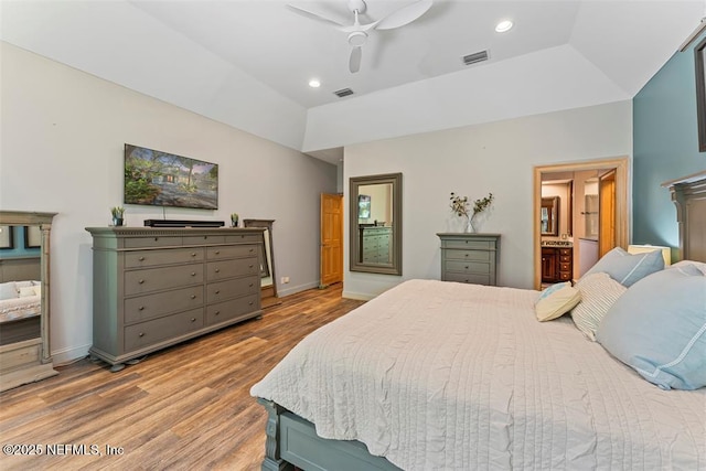 bedroom with lofted ceiling, recessed lighting, wood finished floors, and visible vents