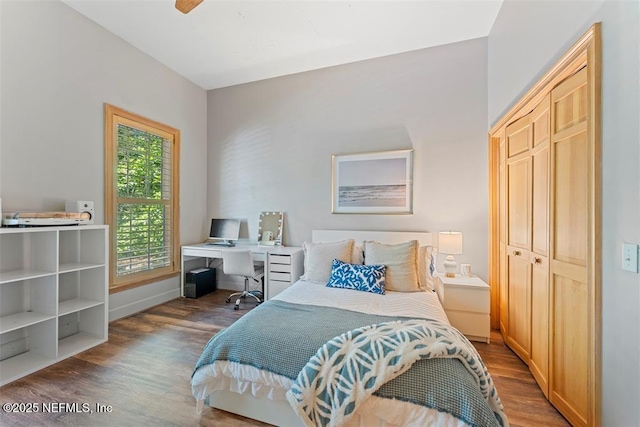 bedroom with ceiling fan, wood finished floors, a closet, and baseboards