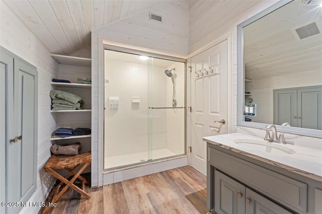 bathroom featuring visible vents, wood finished floors, a shower stall, lofted ceiling, and wood ceiling