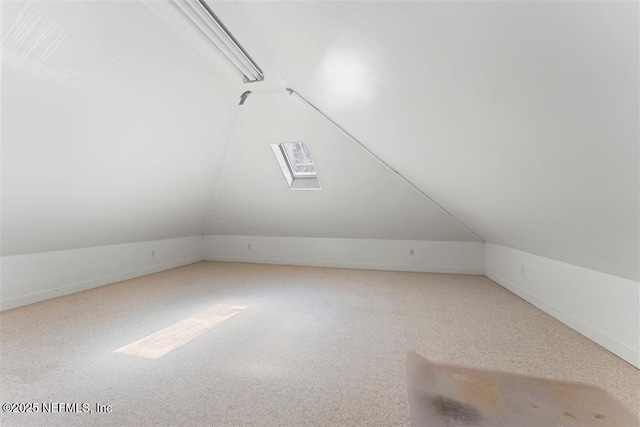 bonus room featuring vaulted ceiling with skylight and carpet