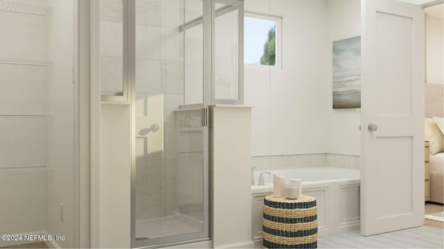 bathroom featuring a spacious closet, a stall shower, and a bath