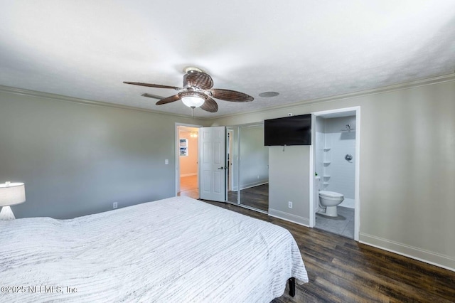 bedroom with baseboards, dark wood-type flooring, ensuite bathroom, and crown molding