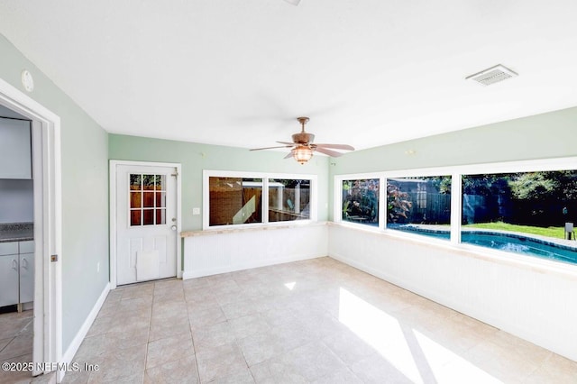 unfurnished sunroom with visible vents and a ceiling fan