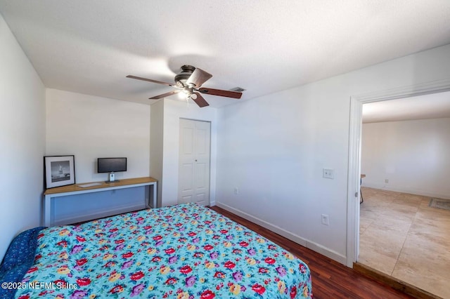 bedroom featuring a textured ceiling, ceiling fan, dark wood-style flooring, visible vents, and baseboards